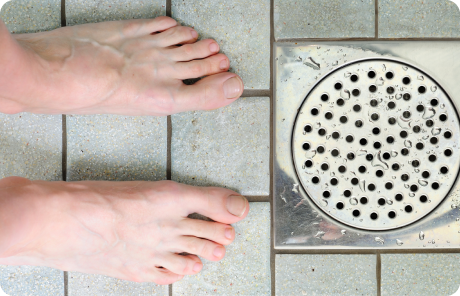 Feet next to shower drain